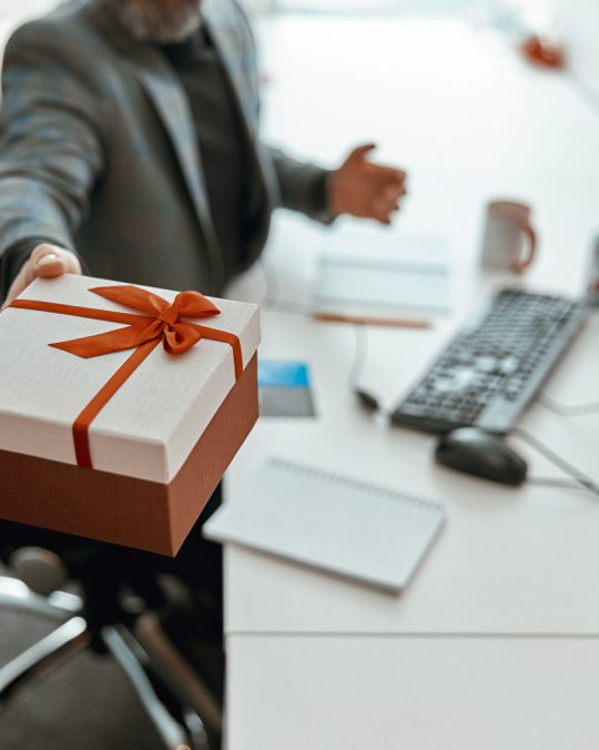 Close up of man holding present gift and sitting at the table